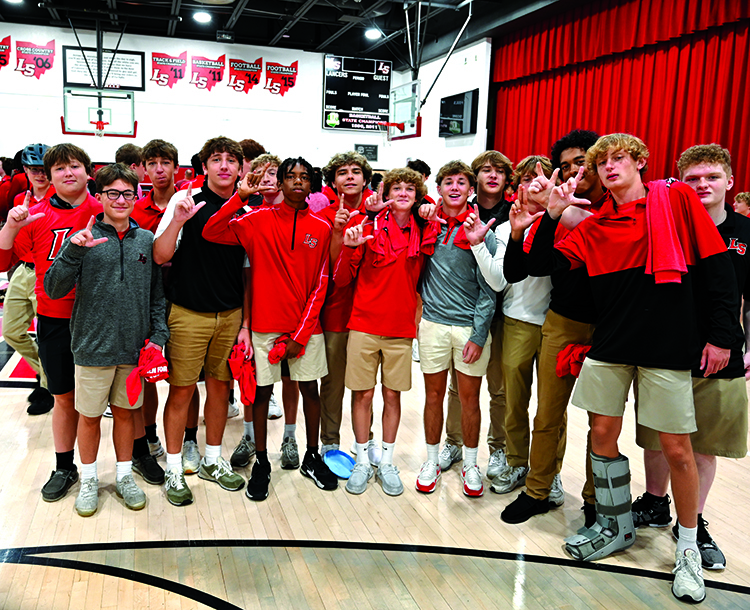 students holding up L's
